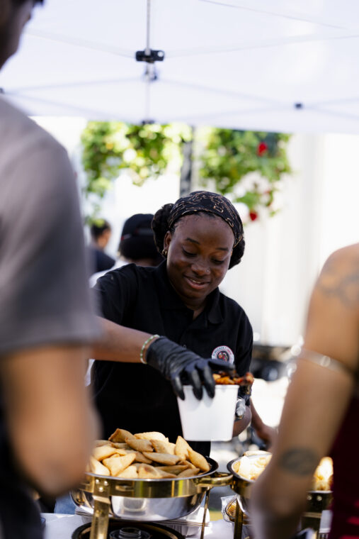 Nkabom Africa Food Celebration. Someone is selling food to a patron.