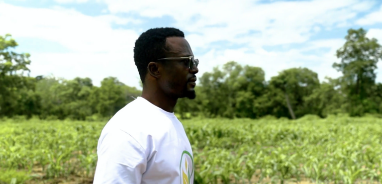 a young man, evans walks down a farm